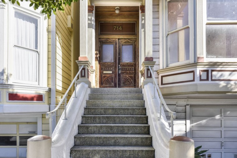 The house for sale at 714 Steiner Street has a gorgeous, sweeping staircase up to the front door.