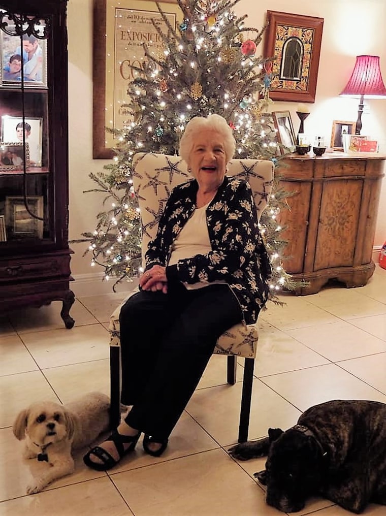 Chia Santiago sits in front of a Christmas tree.