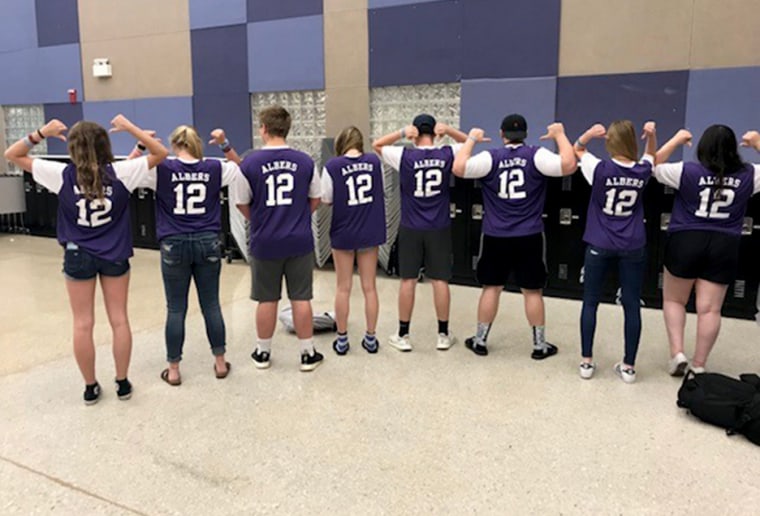 Image: Friends of John Albers, who died in January 2018, wear shirts made in his honor.