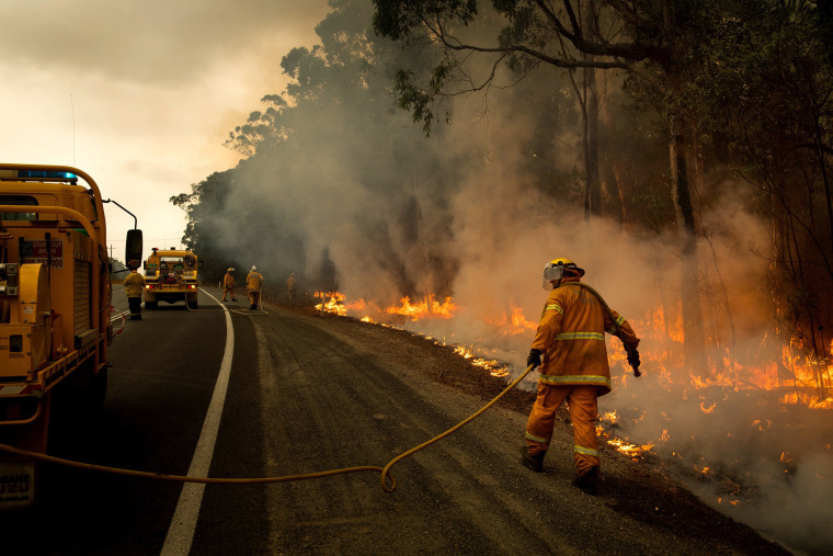 Image: In an effort to create a fire break, volunteer firefighters tend a controlled burn along Princess Highway in Australia's Meroo National Park, Jan. 5, 2020. (Matthew Abbott/The New York Times)