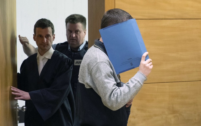 Image: A 57-year old defendant hides his face at the courtroom in Bielefeld, Germany
