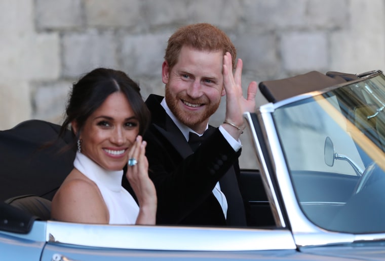 Image: Meghan, Duchess of Sussex and Prince Harry, Duke of Sussex wave as they leave Windsor Castle after their wedding to attend an evening reception at Frogmore House, hosted by the Prince of Wales