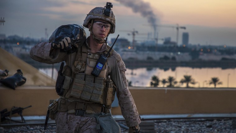 Image: A U.S. Marine with 2nd Battalion, 7th Marines that is part of a quick reaction force, carries a sand bag during the reinforcement of the U.S. embassy compound in Baghdad, Iraq,