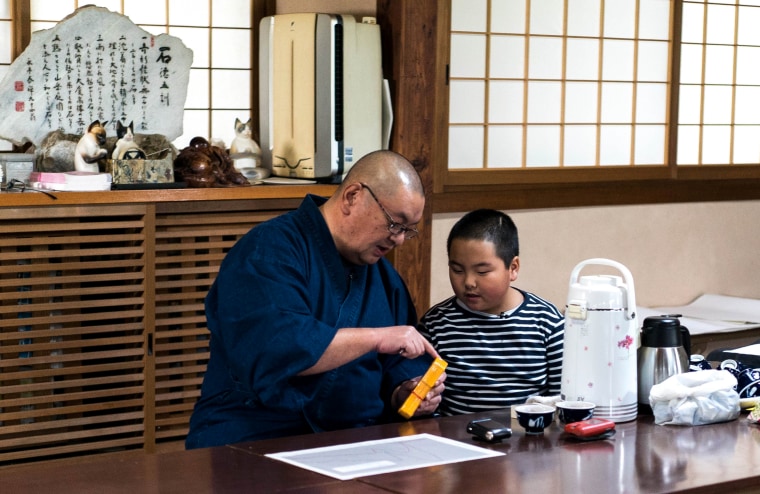 Imae: Buddhist priest Sadamaru Okano looks at geiger counters and radiation charts with his 11-year-old son, Sadahiro, at his temple in Matsukawa Town, Fukushima, Japan.
