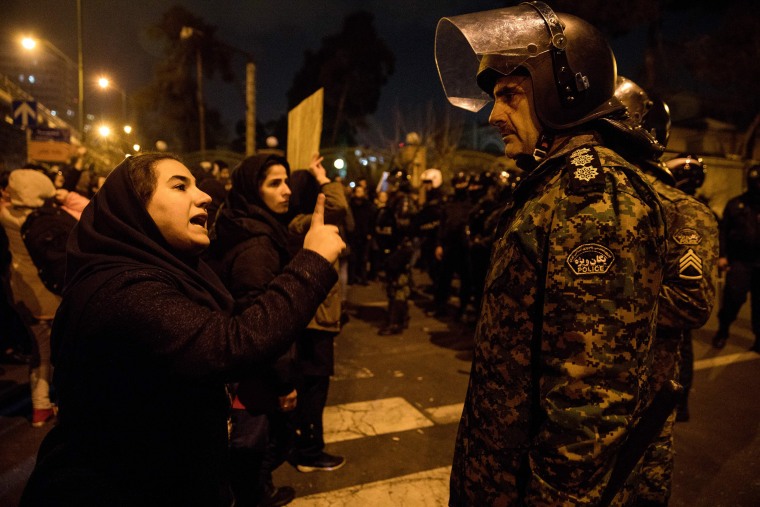 Image: A woman attending a candlelight vigil, in memory of the victims of Ukraine International Airlines Boeing 737, talks to a policeman following the gathering in front of the Amirkabir University in the Iranian capital Tehran