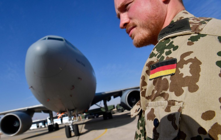 Image: A member of the German contingent standing next to a German air force Airbus A-310 aerial refueling tanker aircraft at the Al Azraq air base in Jordan.
