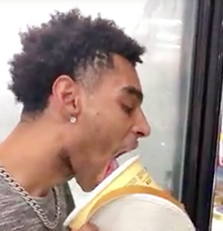 A man licks ice cream from a Blue Bell carton at a Walmart in Port Arthur, Texas.