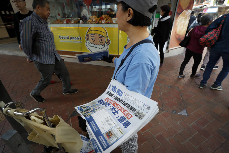 Image: A vendor gives out copies of newspaper with a headlines of "Wuhan break out a new type of coronavirus, Hong Kong prevent SARS repeat" at a street in Hong Kong