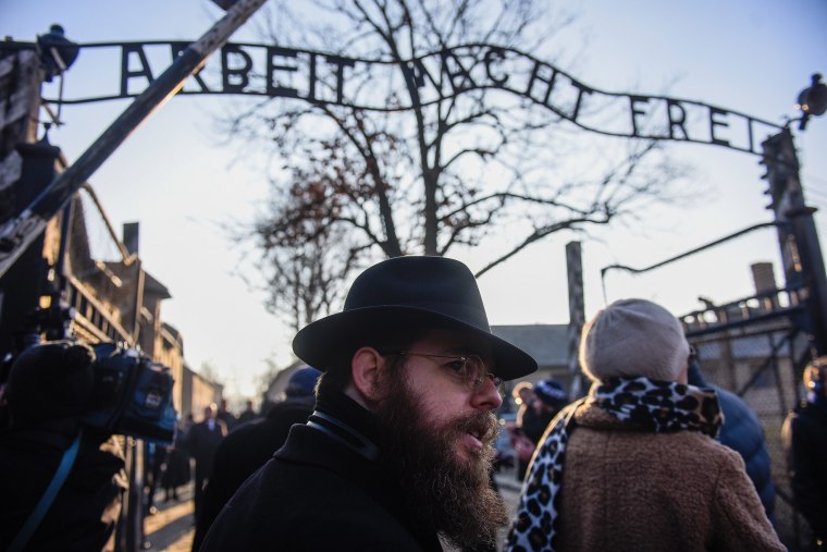 Image: Rabbi Shlomo Koves walks by the main gate of the former Auschwitz concentration camp bearing the motto Arbeit Macht Frei (Work brings freedom) on Jan. 21, 2020 in Oswiecim, Poland.