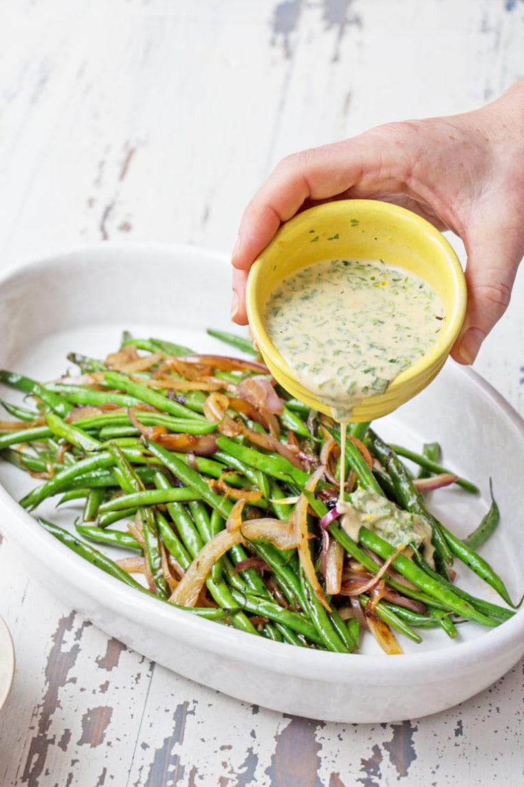 Stir up the dressing and either drizzle if over the whole dish, or pass it at the table for folks to drizzle over their beans as they like.