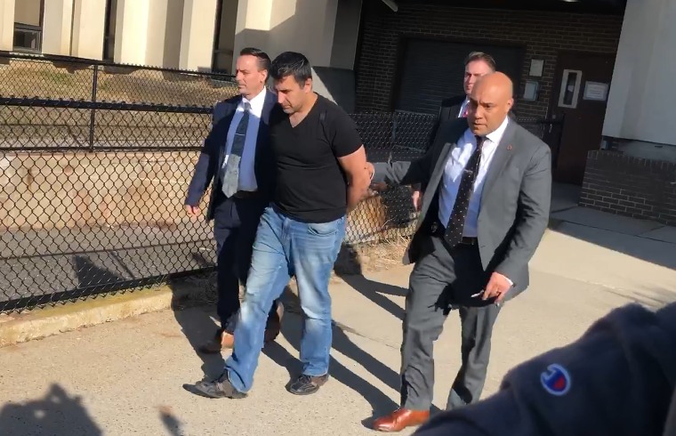 Michael Valva is led in handcuffs to a car on Jan. 24, 2020 in Center Moriches, N.Y.