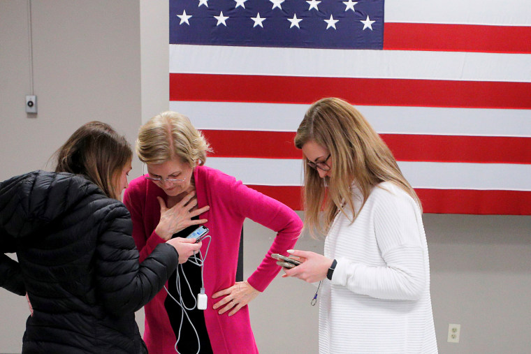 Image: Sen. Elizabeth Warren, D-Mass., is told by an aide that she received the endorsement of the Des Moines Register newspaper in Muscatine, Iowa, on Jan. 25, 2020.