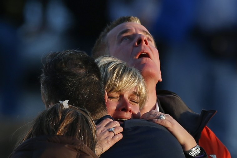 Image: The families of victims grieve near Sandy Hook Elementary School, where a gunman opened fire on school children and staff in Newtown, Connecticut