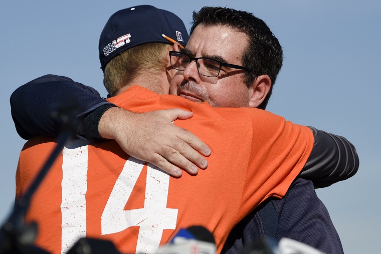 Tony Altobelli, who works as Orange Coast College's sports information director, hugs OCC baseball coach Nate Johnson as they paid tribute to John Altobelli at the baseball team's season opener. 