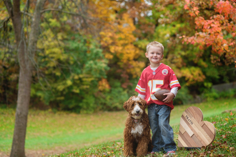 The Glennon family honors Travis in family photos with this wooden heart, and raises money every football season with "Touchdowns for Travis."