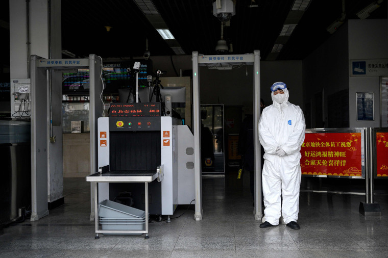 Image: Security personnel wearing protective clothing to help stop the spread of a deadly SARS-like virus at the entrance of subway station in Beijing
