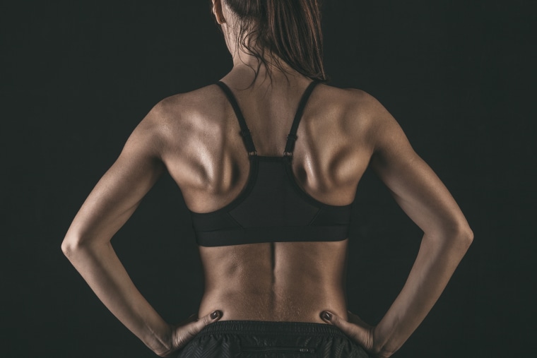 Back View of Healthy Strong Woman in Sportswear Standing in Gym