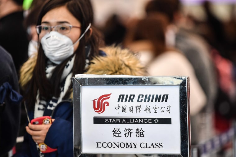 Image: A passenger wearing a respiratory mask waits for check in on Jan. 31, 2020 in a terminal of Rome's Fiumicino airport.