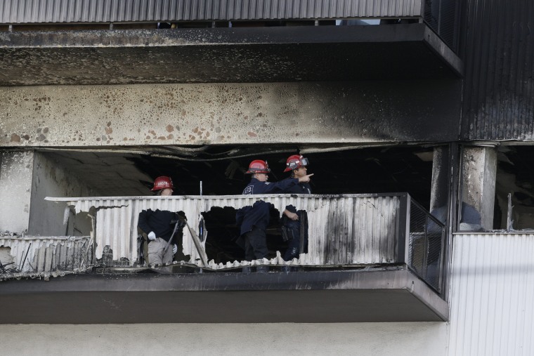 In this Wednesday, Jan. 29, 2020 photo, Los Angeles Fire Department investigators view the charred sixth floor of a residential building in Los Angeles.