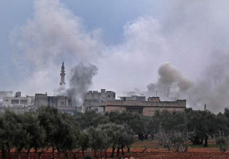 Image: Smoke plumes billowing from bombardment by the Syrian government forces and allies on the town of Sarmin, southeast of the city of Idlib