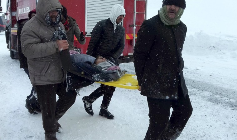 Image: Emergency service members carry a casualty at the site of avalanche near the town of Bahcesehir, in Van province, eastern Turkey