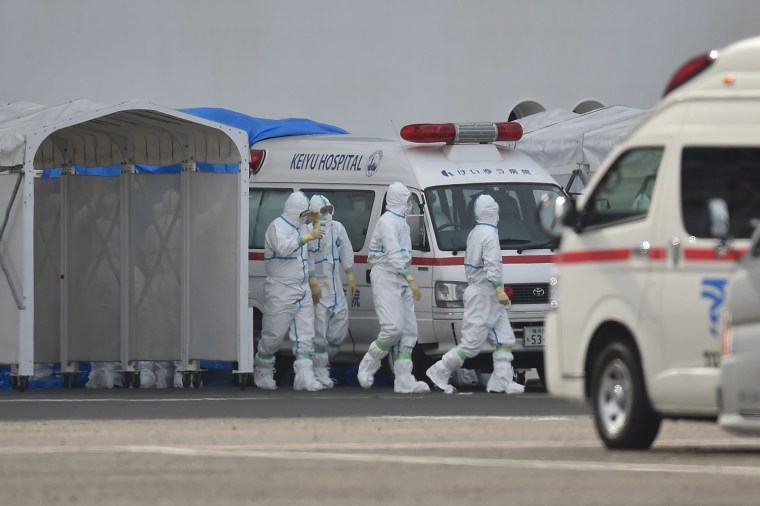 Image: Medical staff wearing protective gear prepare to provide care for suspected coronavirus patients on board the quarantined Diamond Princess cruise ship in Yokohama on Friday.