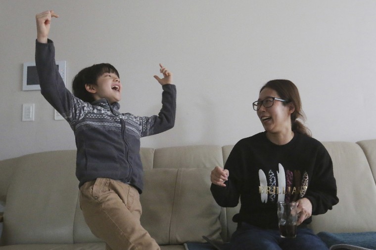 Image: "Parasite" actor Jeong Hyeon-jun, left, and his mother Lee Min-jae celebrate in Seoul as they watch the Oscars.