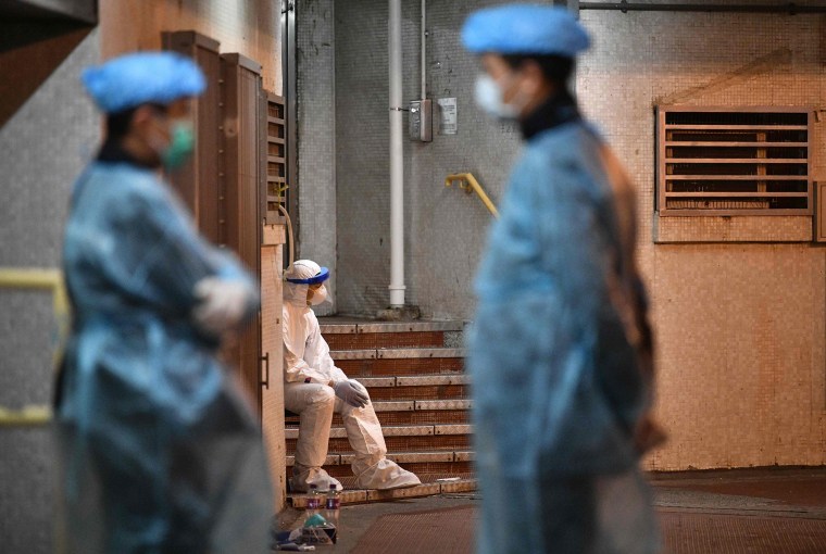 Image: Medical personnel wearing protective suits stay near a block's entrance on the grounds of a residential estate in Hong Kong, early on Feb. 11, 2020.
