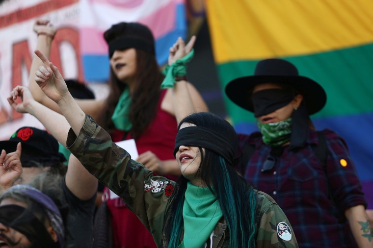 A woman performs the song 'A rapist in your path' during a demonstration against gender violence at Angel de la Independencia monument in Mexico City