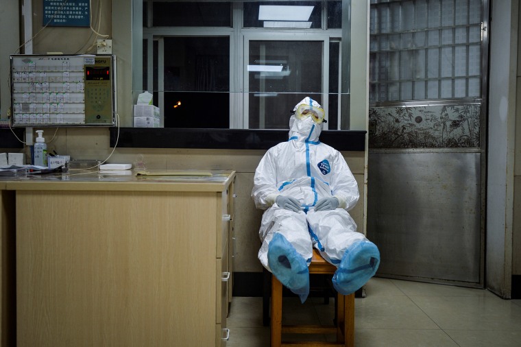 Image: A medical worker in protective suit takes a break during her night shift at a community health service center in the Qingshan district of Wuhan, Hubei province.