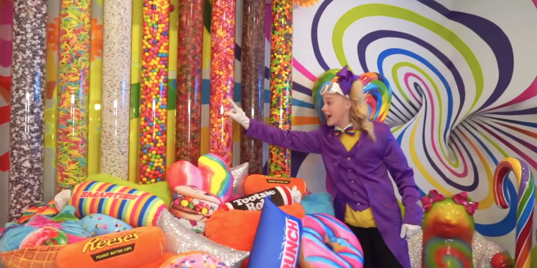 Siwa points to her headboard, which is giant tubes of candy.