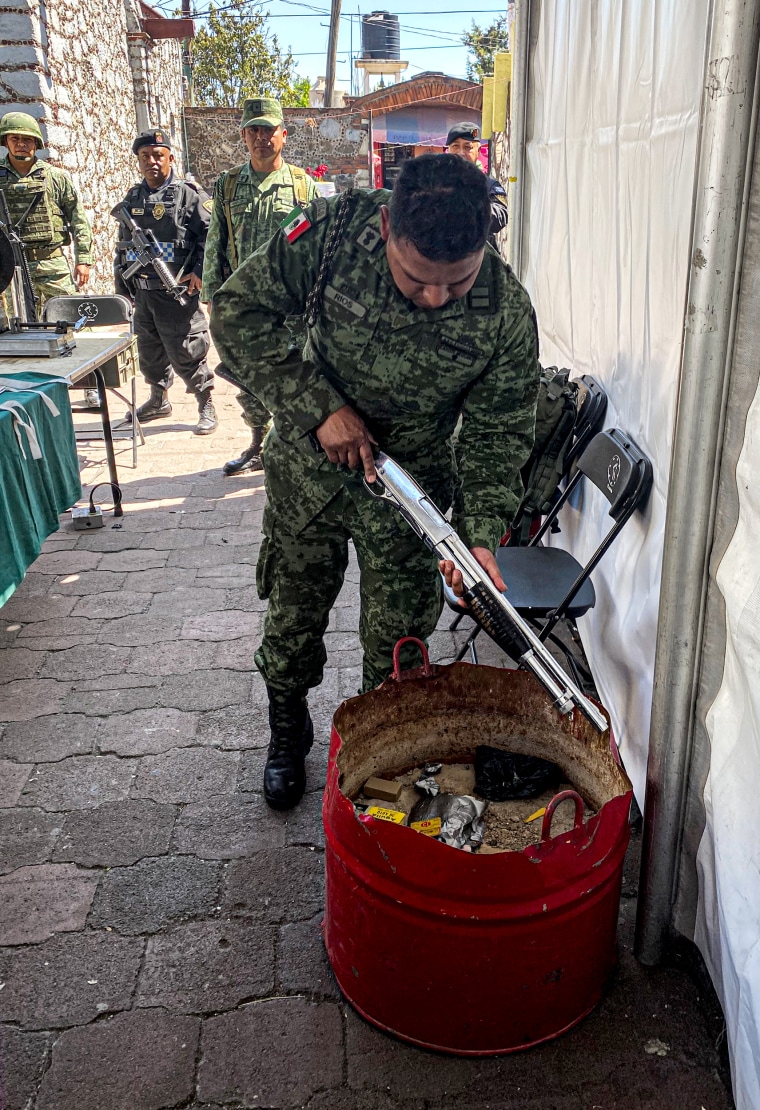 Image: Members of the Mexican military check weapons are not loaded after they've been turned in by citizens as part of a gun buyback program.