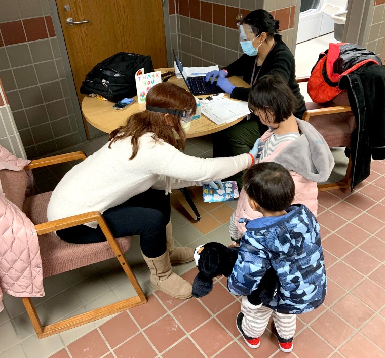 A CDC employee performs a final health check on children who were evacuated from Wuhan, and completed their mandatory 14-day quarantine at Camp Ashland in Nebraska.