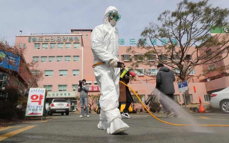 Image: A South Korean health official sprays disinfectant in front of a hospital where a total of 16 infections have now been identified with the COVID-19 coronavirus, in Cheongdo county near the southeastern city of Daegu