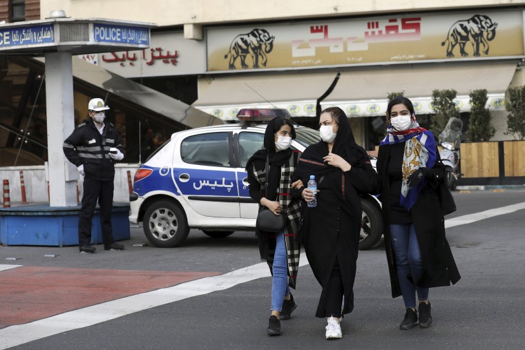 Image: A policeman and pedestrians wear masks to help guard against the Coronavirus, in downtown Tehran, Iran