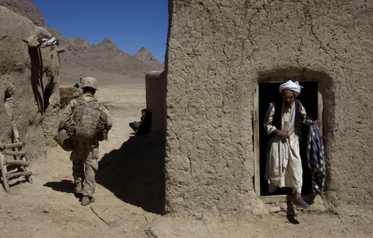 Image: An Afghan man steps out of his house