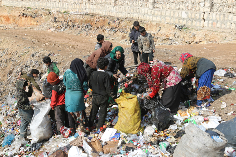 Image: Children pick through a landfill site looking for paper and plastic to burn.