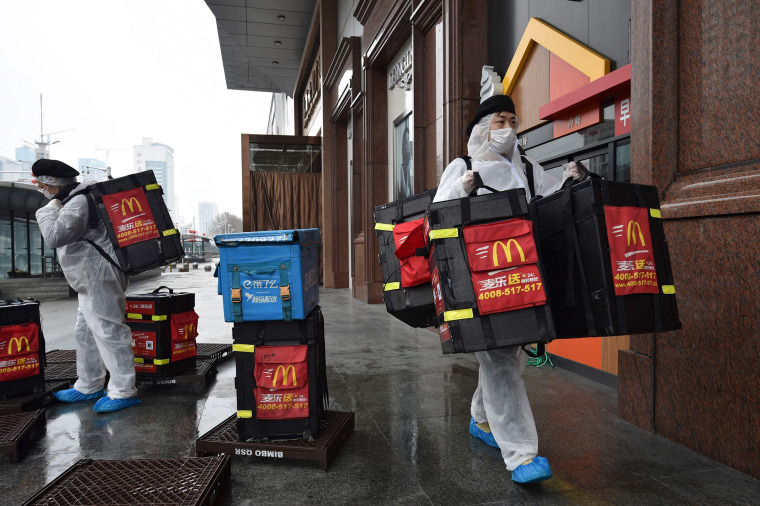 Image: McDonalds workers wear protective suits as they deliver food in the epidemic's epicenter of Hubei province 