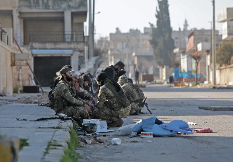 Image: Turkey-backed Syrian fighters rest in the town of Saraqib in Syria's Idlib province 