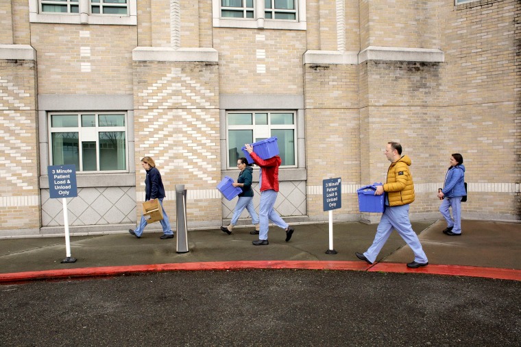 Image: Harborview Medical Center?EUR(TM)s home assessment team carry protective and testing supplies while preparing to visit the home of a person potentially exposed to novel coronavirus at Harborview Medical Center in Seattle