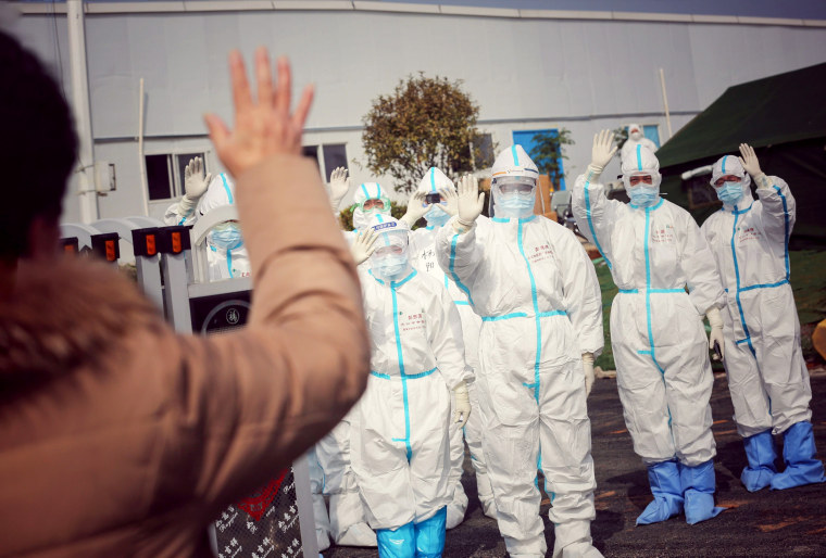 Image: Medical staff wave to a former patient who recovered from coronavirus at the makeshift Leishenshan Hospital in Wuhan, China, on March 1, 2020.
