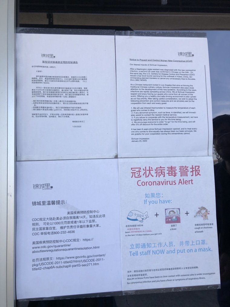 A coronavirus warning sign posted in the window of Sichuan Impression in Tustin, California