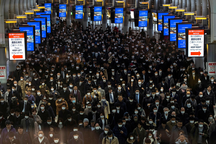 Image: Crowds wearing protective masks, following an outbreak of the coronavirus, are seen at the Shinagawa station in Tokyo