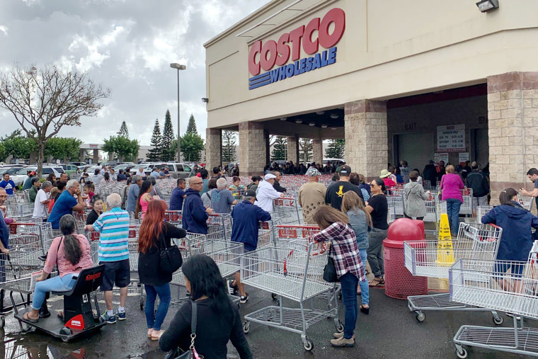 Image: Shoppers in a Costco stock up on a 14-day supply of food, water and other necessities in Honolulu