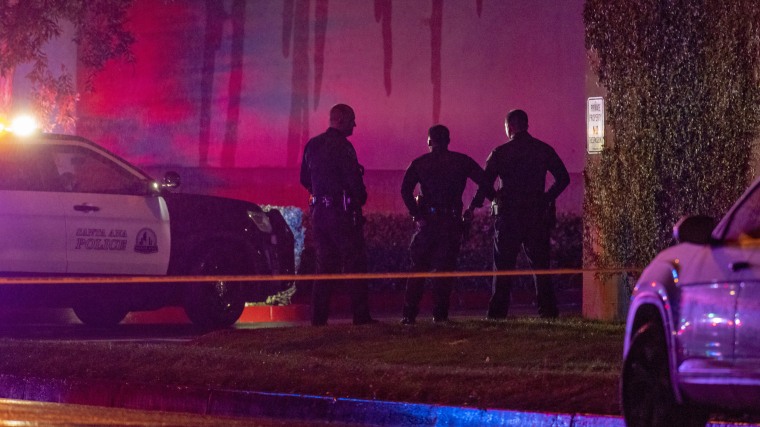 Detectives stand by the scene where an armed man was shot by police at Immaculate Heart of Mary Church in Santa Ana, Calif., on March 1, 2020.