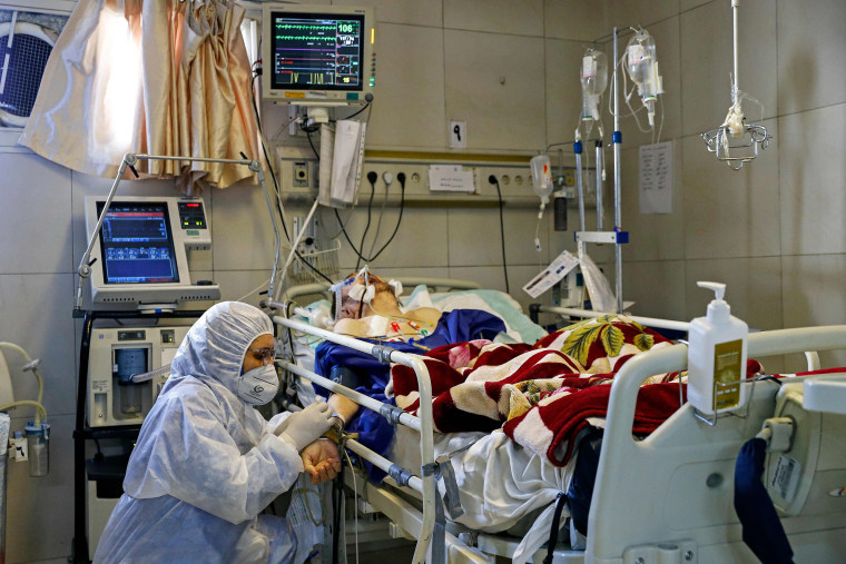 Image: An Iranian medic treats a patient infected with the COVID-19 virus at a hospital in Tehran