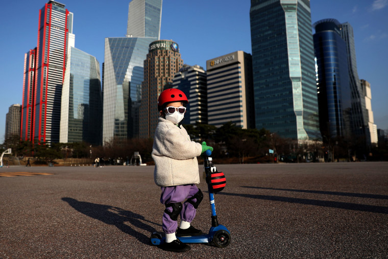 Image: A South Korean child wears a mask to prevent catching the coronavirus (COVID-19) while riding a scooter on Feb. 27, 2020 in Seoul, South Korea.