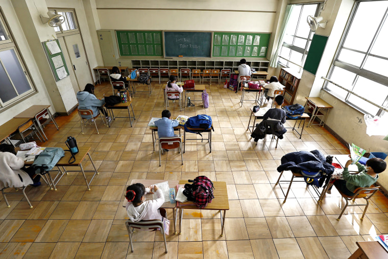 Image: Students sit apart from each other as they do self-study at an elementary school where the facility was opened for children who cannot stay at home alone while their parents are at work, in Nagoya, central Japan