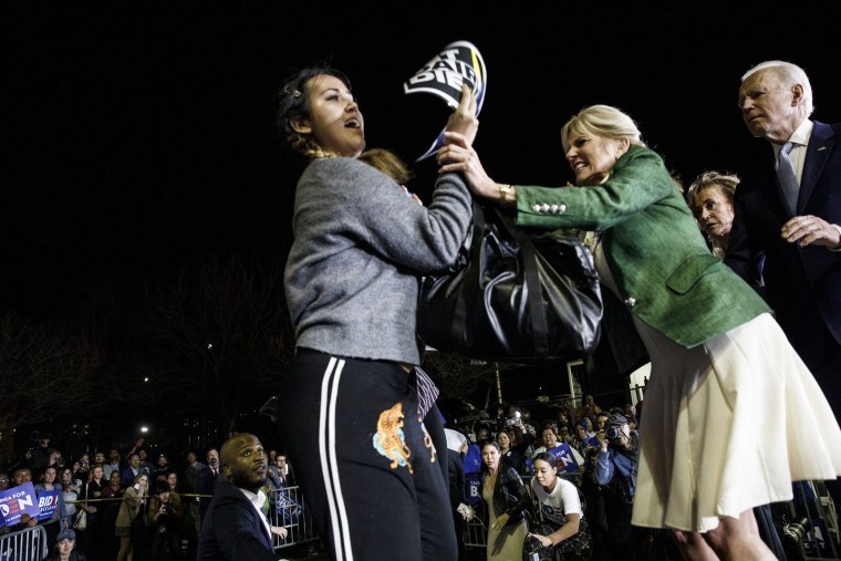 Image: Former Vice President Joe Biden, 2020 Democratic presidential candidate, right, watches as his wife Jill Biden, center, blocks a protester from arriving on stage during an primary night rally in the Baldwin Hills neighborhood of Los Angeles