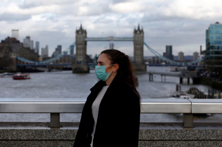 Image: A woman wearing a protective face mask on London Bridge in London